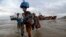 FILE — Displaced families arrive after being rescued by boat from a flooded area of Buzi district, 200 kilometers (120 miles) outside Beira, Mozambique, March 23, 2019.