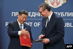 Chinese President Xi Jinping and Serbian President Aleksandar Vucic prepare to shake hands after signing bilateral documents during a meeting in Belgrade, May 8, 2024.