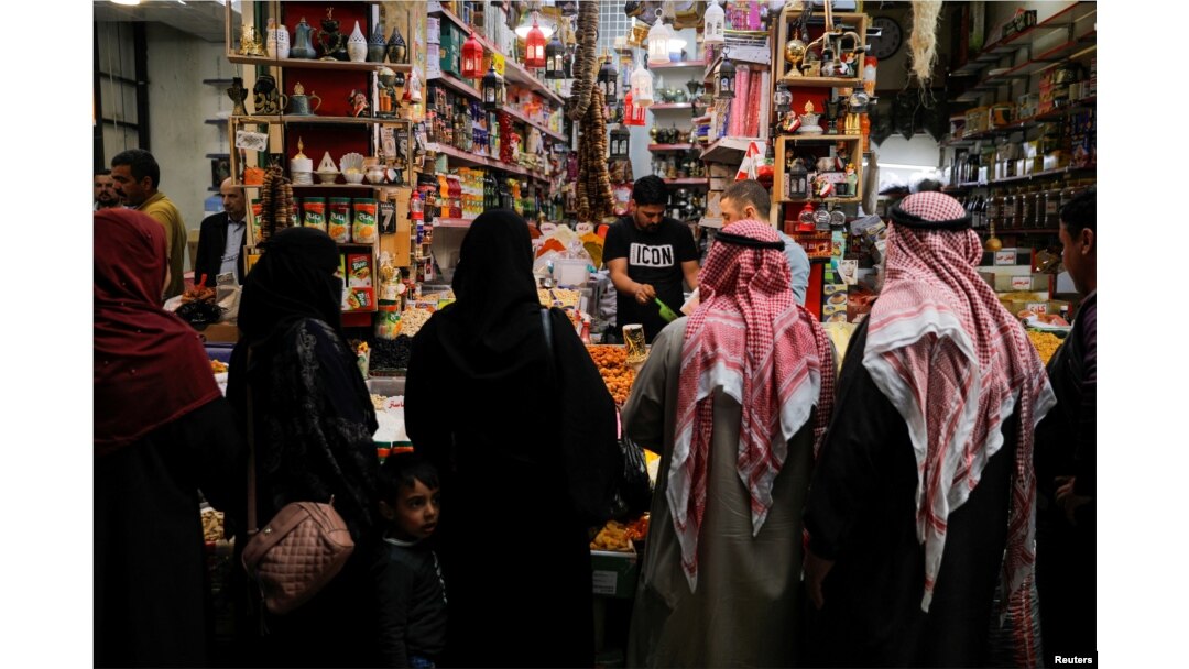 Warga berbelanja di pasar grosir menjelang bulan suci Ramadan, di tengah kenaikan harga komoditas seperti minyak goreng dan gandum, menyusul invasi Rusia ke Ukraina, di Mosul, Irak, 31 Maret 2022. (REUTERS/Khalid Al-Mousily)