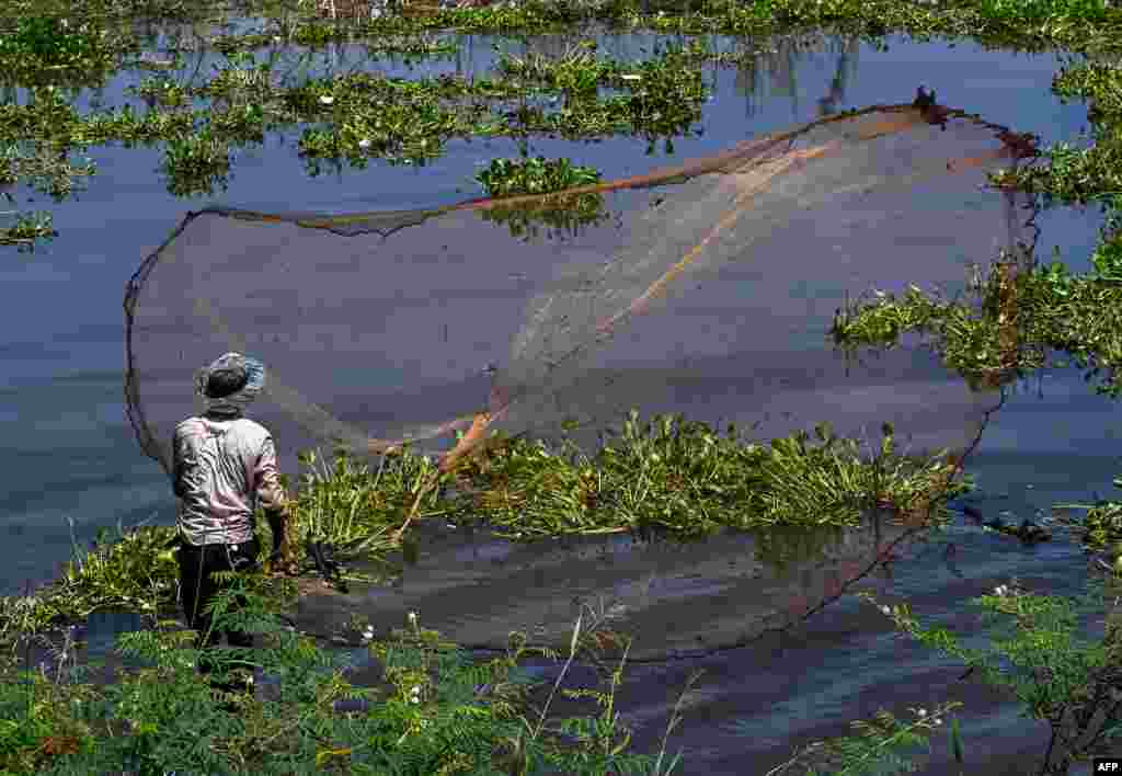 A man throws a fishing net into a lake in Kandal province, near Phnom Penh, Cambodia.