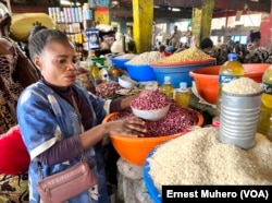 Mwanamke akiuza nafaka mbalimbali katika soko la eneo huko Bukavu, DRC ambako bei ya vyakula imepanda kutokana na mfumuko wa bei, Februari 2023. (Photo: Ernest Muhero/VOA)