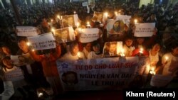(FILE) Catholics in Vietnam hold a mass prayer for an activist who was arrested by the government.