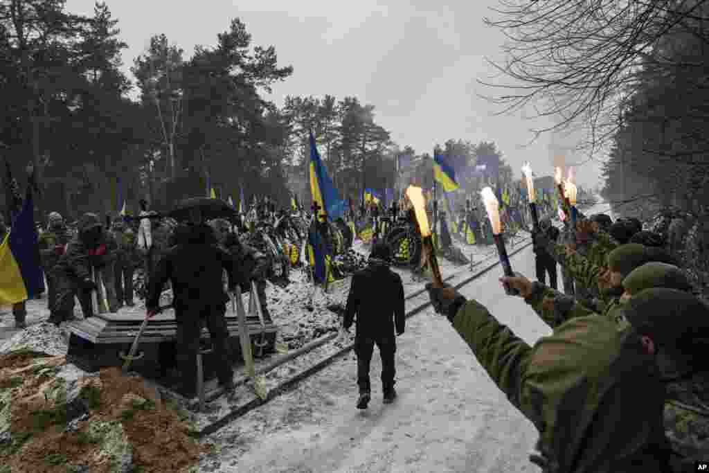 Funeral workers down a coffin into a grave during a funeral ceremony of Sviatoslav Romanchuk, Ukrainian serviceman, at the cemetery in Kyiv, Jan. 3, 2024.&nbsp;Romanchuk joined territorial defense since the beginning of or Russian invasion and was killed on Dec. 28, 2023 in Lyman direction, Donetsk region.&nbsp;