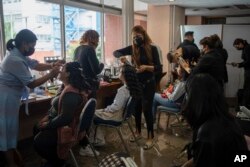 Volunteers style hair and apply makeup to 15-year-olds in preparation for the annual “Mis XV” or “My Fifteenth” birthday celebration for patients at the Federico Gomez Children’s Hospital in Mexico City, Aug. 9, 2024.