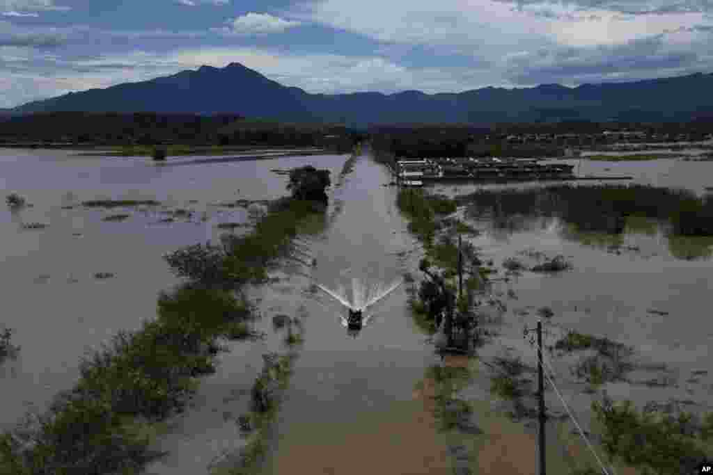 Residents cross a submerged road in a boat after deadly rainfall in Duque de Caxias, Brazil, Jan. 15, 2024. 