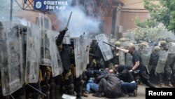 Soldados de la Fuerza de la OTAN en Kosovo (KFOR, por sus siglas en inglés) chocan con manifestantes locales serbokosovares en la entrada de la oficina municipal, en la ciudad de Zvecan, Kosovo, el 29 de mayo de 2023.