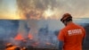 En esta foto proporcionada por el Servicio Geológico de EEUUm un científico observa la erupción en curso que tiene lugar en la cima del volcán Kilauea en Hawái, el miércoles 7 de junio de 2023. 