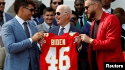 U.S. President Joe Biden holds a jersey of the Kansas City Chiefs next to Patrick Mahomes and Travis Kelce as the team visits the White House to celebrate their championship season and victory in Super Bowl LVII, in Washington, June 5, 2023. 