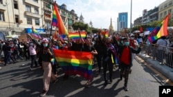 FILE - Protesters from the LGBTQ community hold rainbow flags as they march in Yangon, Myanmar, Feb. 8, 2021.