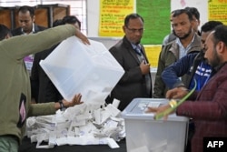 Election officials prepare to count ballot papers at a polling booth in Dhaka on Jan. 7, 2024.