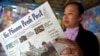 FILE - A Cambodian vendor reads The Phnom Penh Post at her newstand in Phnom Penh on May 7, 2018.