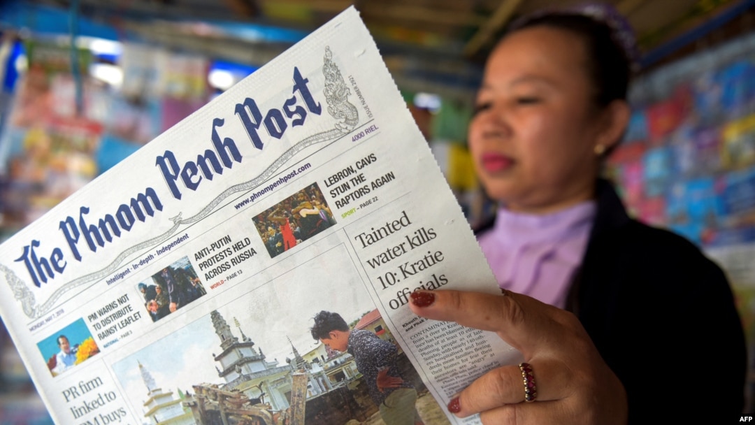 Seorang pedagang asal Kamboja membaca The Phnom Penh Post di kios barunya di Phnom Penh pada 7 Mei 2018. (Foto: AFP)