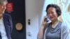 Chinese Australian journalist Cheng Lei, right, talks on the phone as Australia's Minister for Foreign Affairs, Penny Wong, watches at Tullamarine Airport in Melbourne, Oct. 11, 2023. 