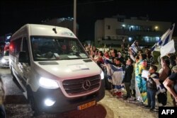 People cheer as a vehicle carrying hostages released by Hamas drives towards an army base in Ofakim, southern Israel, on Nov. 26, 2023, after they were released by Hamas from the Gaza Strip.