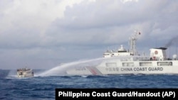 A Chinese Coast Guard ship uses water cannons on Philippine navy-operated supply boat M/L Kalayaan as it approaches Second Thomas Shoal, locally known as Ayungin Shoal, in the disputed South China Sea, Dec. 10, 2023.