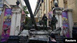 Pasukan kelompok tentara bayaran swasta Wagner berdiri di atas tank di luar sirkus lokal dekat markas besar Distrik Militer Selatan di kota Rostov-on-Don, Rusia, 24 Juni 2023. (Foto: Reuters)