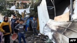 Children check damage of a makeshift shelter in a camp set up by displaced Palestinians near the Emirati hospital in Rafah in the southern Gaza Strip, in which several people were reported killed when it was hit by Israeli bombing on March 2, 2024.