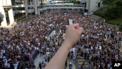 FILE - Tens of thousands of people march through a Hong Kong street July 1, 2003, to protest the Hong Kong government's plans to enact an anti-subversion bill that critics feared would curtail civil liberties.