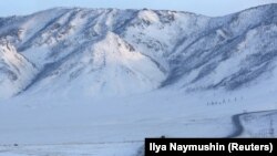 Sebuah truk melaju di sepanjang jalan raya federal R257 saat matahari terbenam di utara kota Kyzyl di Siberia Selatan, Rusia, 13 Februari 2018. (Foto: REUTERS/Ilya Naymushin)