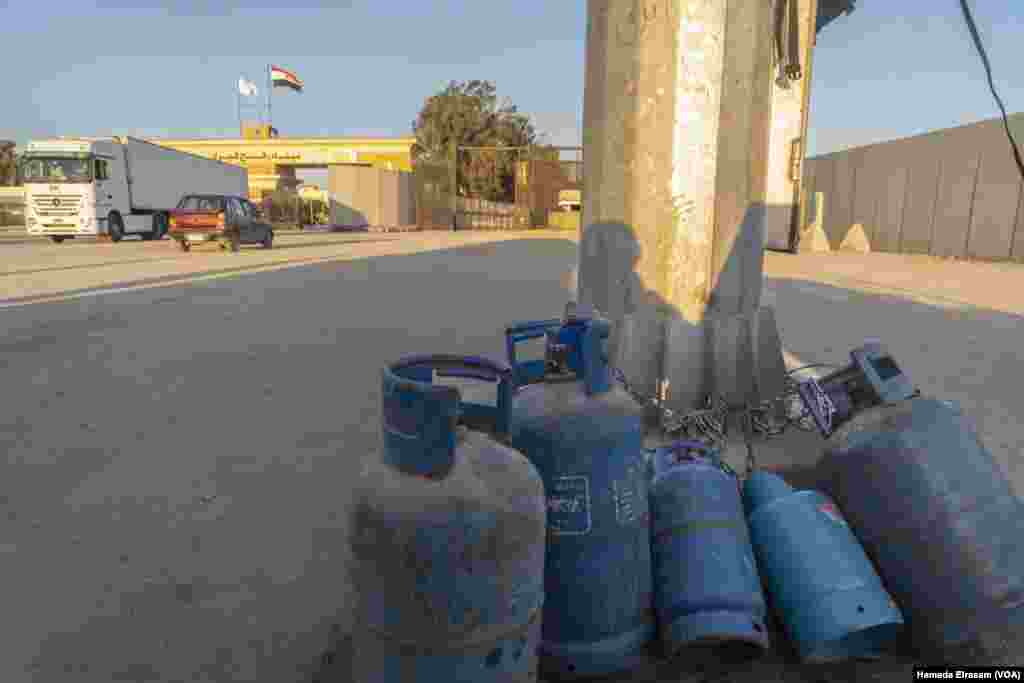 These gas cylinders belong to aid truck drivers who use them for cooking on-the-road meals but had to leave them behind, chained to this column, before entering the gates of the Rafah crossing, Egypt.