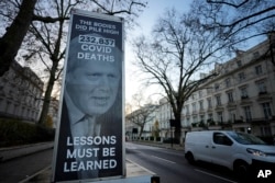 Sebuah mobil van yang menampilkan spanduk protes diparkir di luar Penyelidikan COVID-19 di London, Rabu, 6 Desember 2023. (AP/Kirsty Wigglesworth)