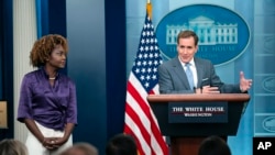 White House press secretary Karine Jean-Pierre, left, listens to National Security Council spokesman John Kirby speak at the White House in Washington, Oct. 12, 2023. Creating a humanitarian corridor to enable aid to reach Palestinians in Gaza is "the right thing to do," he said.
