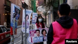 A volunteer campaigns for the New People's Party during the District Council election in Hong Kong, Dec. 10, 2023. 