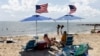 FILE - People fly the American flag on their beach umbrellas, Aug. 30, 2024, in Dennis Port, Mass. 