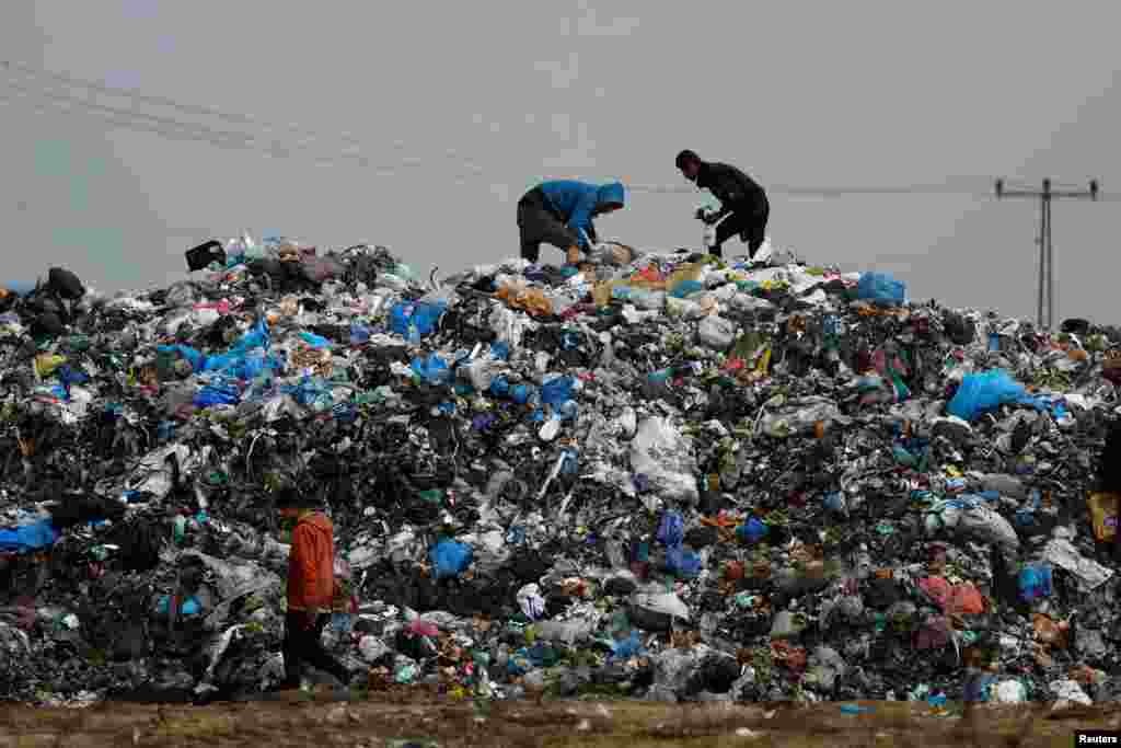 Palestinians look through trash in Rafah, southern Gaza Strip.