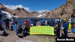 Azərbaycanlı alpinistlər Urmiyə gölünün vəziyyətini tənqid edən plakat nümayiş etdirir