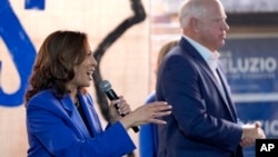 Democratic presidential nominee Vice President Kamala Harris speaks as Democratic vice presidential nominee Minnesota Gov. Tim Walz listens at a campaign event, in Rochester, Pennsylvania, Aug. 18, 2024.