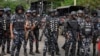 Nigeria police watch a procession in honor of protesters killed in recent economic hardship protests, in Lagos, Aug. 9, 2024. U.N. and police authorities held a summit on Aug. 12 in the capital to discuss the role of youths in national security intelligence.