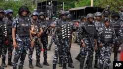 Nigeria police watch a procession in honor of protesters killed in recent economic hardship protests, in Lagos, Aug. 9, 2024. U.N. and police authorities held a summit on Aug. 12 in the capital to discuss the role of youths in national security intelligence.