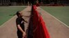 Richard Tsoi, former leader of now-disbanded Hong Kong Alliance in Support of Patriotic Democratic Movements of China, poses for photographs next to a closed pitch at Victoria Park in Hong Kong, Monday, May 29, 2023. 