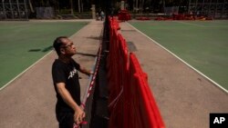 Richard Tsoi, former leader of now-disbanded Hong Kong Alliance in Support of Patriotic Democratic Movements of China, poses for photographs next to a closed pitch at Victoria Park in Hong Kong, Monday, May 29, 2023. 