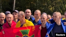 Ukrainian prisoners of war (POWs) react after a swap, at an unknown location in Ukraine, in this handout picture released Aug. 24, 2024. (Ukraine's President Zelenskyy via Telegram/Handout via Reuters) 