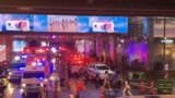 Ambulances wait outside an exit of the Siam Paragon Mall while shoppers rush out after shots are fired inside, in Bangkok, Thailand, Oct. 3, 2023.