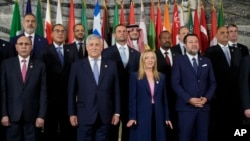 Participants at an International conference on migration pose for a family photo in Rome, July 23, 2023. 