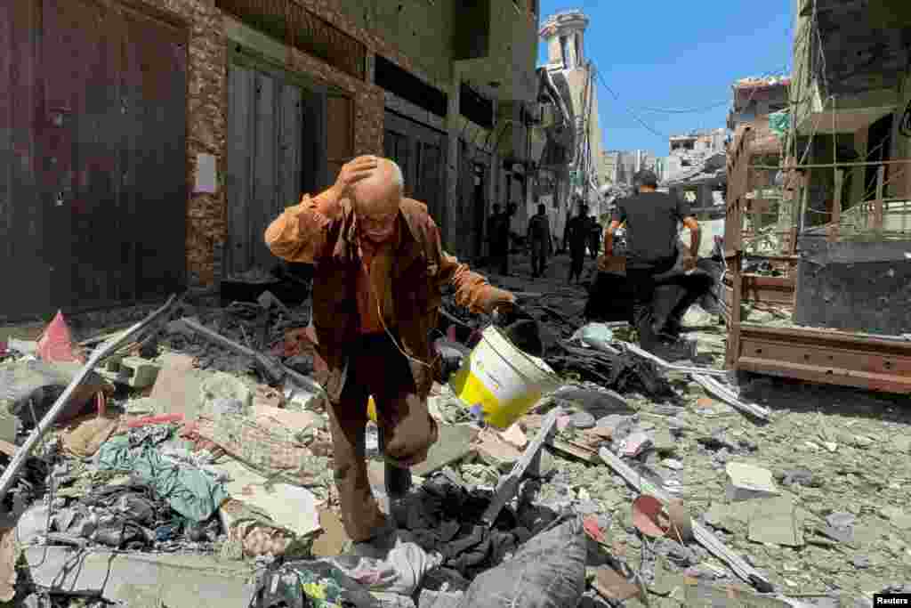 A Palestinian man walks near an apartment hit in an Israeli strike in Gaza City amid Israel-Hamas conflict.