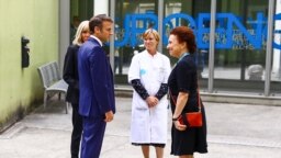 Presiden Prancis Emmanuel Macron (kedua dari kiri), bersama istrinya Brigitte Macron (kiri) disambut Direktur CHU Grenoble Monique Sorrentino (kanan) setibanya di Rumah Sakit Universitas (CHU) di Grenoble, Pegunungan Alpen Prancis, pada 9 Juni 2023. (Benoit Lagneux / POOL / AFP)