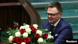 Co-leader of Third Way coalition Szymon Holownia receives flowers after he was elected as the new Speaker of Parliament, during the first session of the newly elected Polish parliament in Warsaw, Poland, Nov. 13, 2023. 