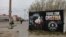 FILE - A person walks near a defaced painting of Argentina's Vice President Cristina Fernandez de Kirchner with the writing reading "All with Cristina" and "Thief, corrupt," in Rio Gallegos, Argentina October 10, 2023.