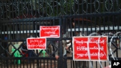 FILE - Prison officers and police gather near the entrance of Insein Prison in Yangon, Myanmar, Oct. 18, 2021.