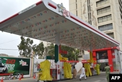 Commuters walk past a closed fuel station amidst a nationwide strike to protest against the hike in tax, in Karachi, Pakistan, July 5, 2024.