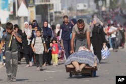 Los palestinos huyen al sur de la Franja de Gaza por la calle Salah al-Din en Bureij, Franja de Gaza, el 8 de noviembre de 2023. (Foto AP/Hatem Moussa)