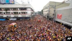 Sekelompok besar umat Katolik yang sebagian besar bertelanjang kaki bergabung dalam prosesi tahunan untuk menghormati Black Nazarene, di pusat kota Manila, Filipina, 9 Januari 2024. (AP/Aaron Favila)