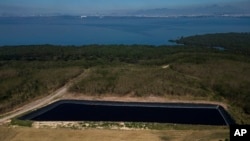 A view of an area that was once part of the Gramacho neighborhood landfill, then considered one of the largest in Latin America, backdropped by a recovered mangrove forest, in Duque de Caxias, Brazil, July 25, 2023.