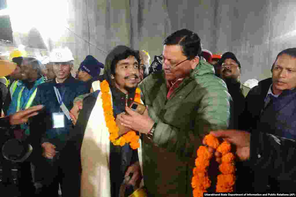 Pushkar Singh Dhami, right, Chief Minister of the state of Uttarakhand, greets a worker rescued from the site of an under-construction road tunnel that collapsed in Silkyara in the northern Indian state of Uttarakhand, India.