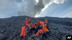 In this undated photo released Dec. 5, 2023, by the Indonesian National Search and Rescue Agency (BASARNAS), rescuers prepare to evacuate the body of a climber killed in Mount Marapi's eruption in Agam, West Sumatra, Indonesia. 