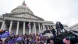 FILE - Rioters loyal to U.S. President Donald Trump swarm the U.S. Capitol in Washington, Jan. 6, 2021. Jason Donner, a former Fox News producer, says in a lawsuit that he was fired for pushing back against false claims about the riot.